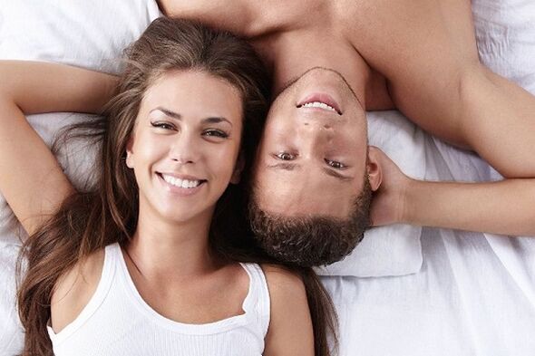 ženska v postelji z moškim, ki je naravno povečal potenco